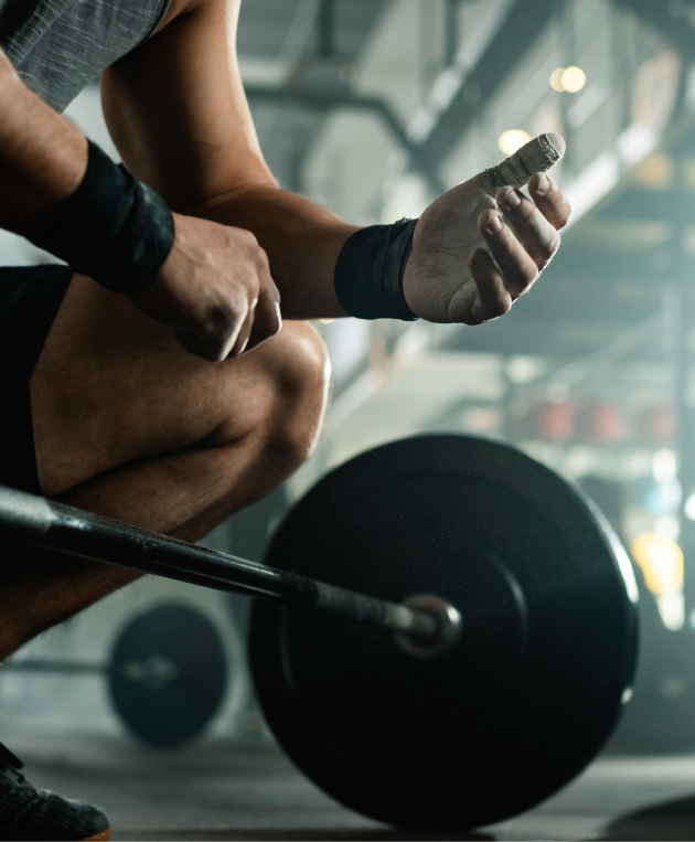 low-angle-view-unrecognizable-muscular-build-man-preparing-lifting-barbell-health-club 1